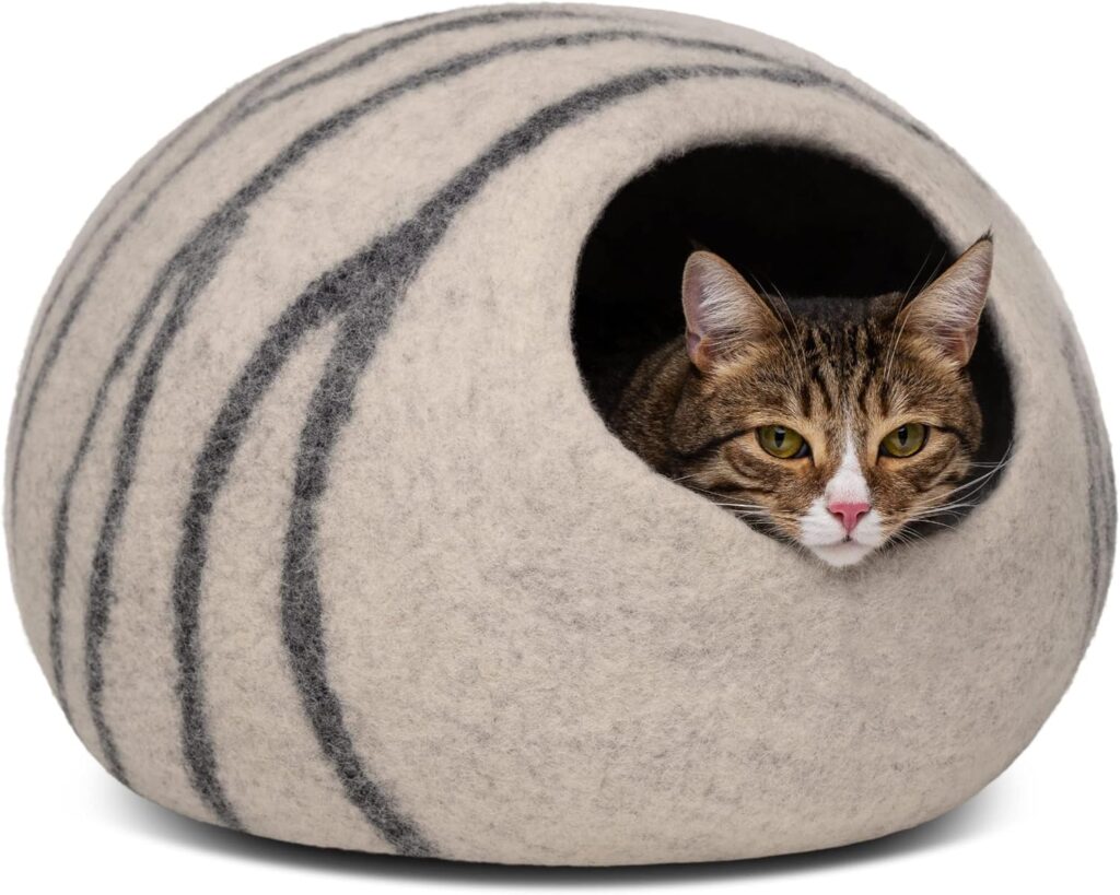 Senior cat resting inside a warm wool cat cave for indoor comfort.